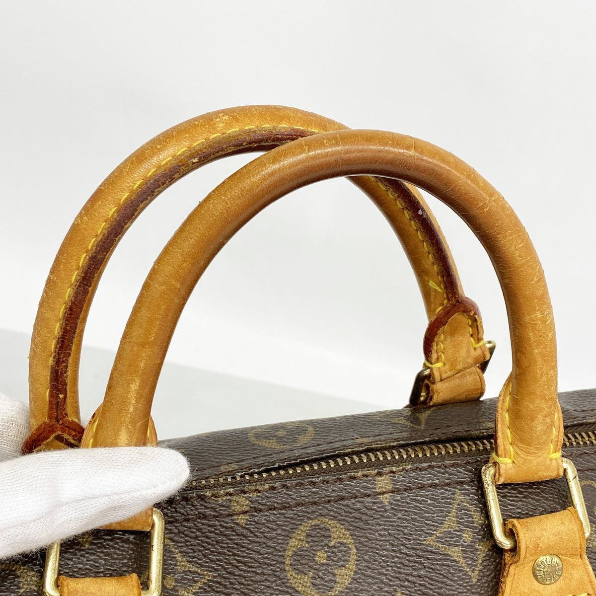 Louis Vuitton Speedy 30 nærbilde av håndtaksfeste med gul søm og beslag
